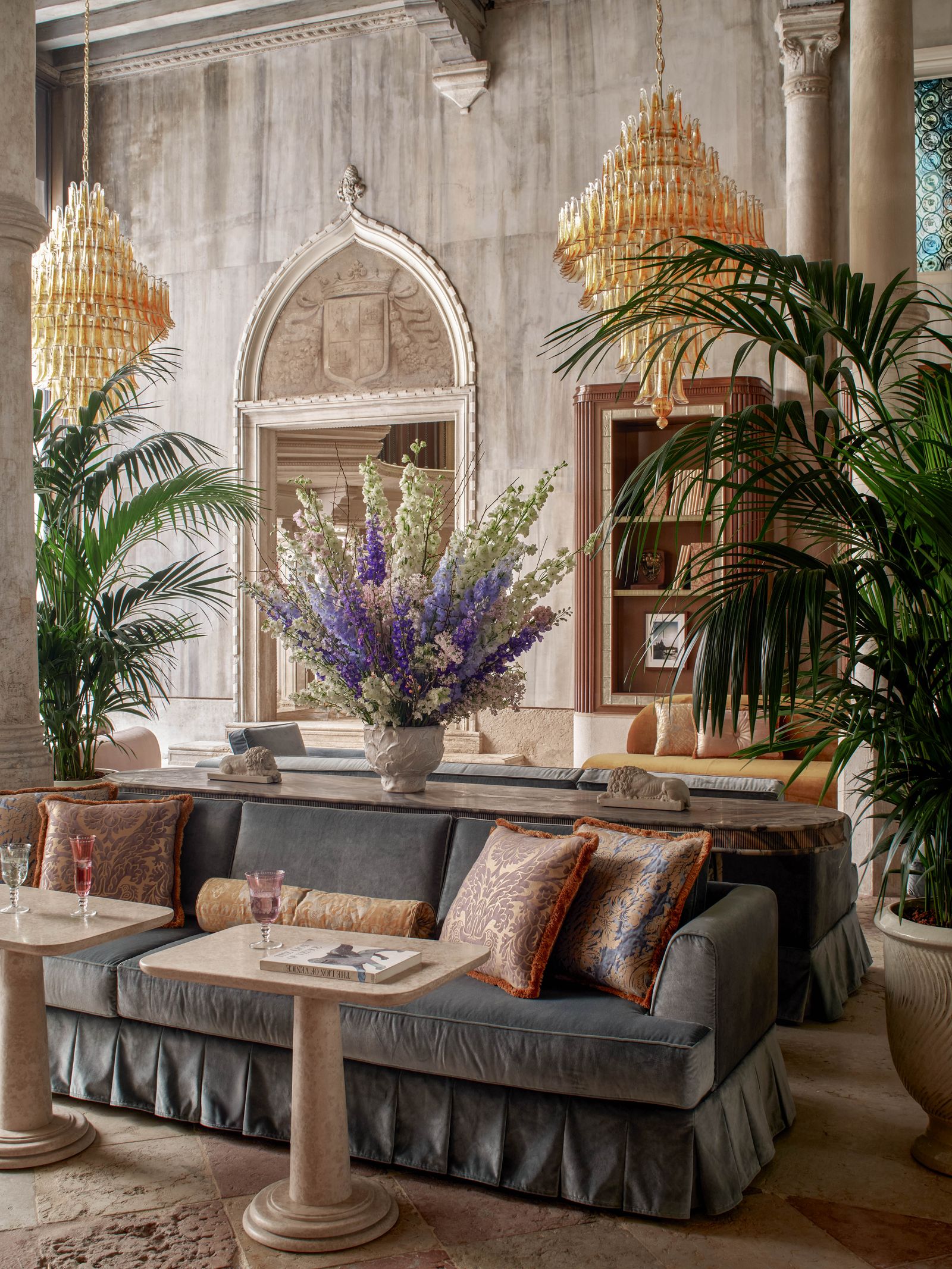 Image may contain Home Decor Plant Chandelier Lamp Couch Furniture Cushion Architecture Building and Indoors