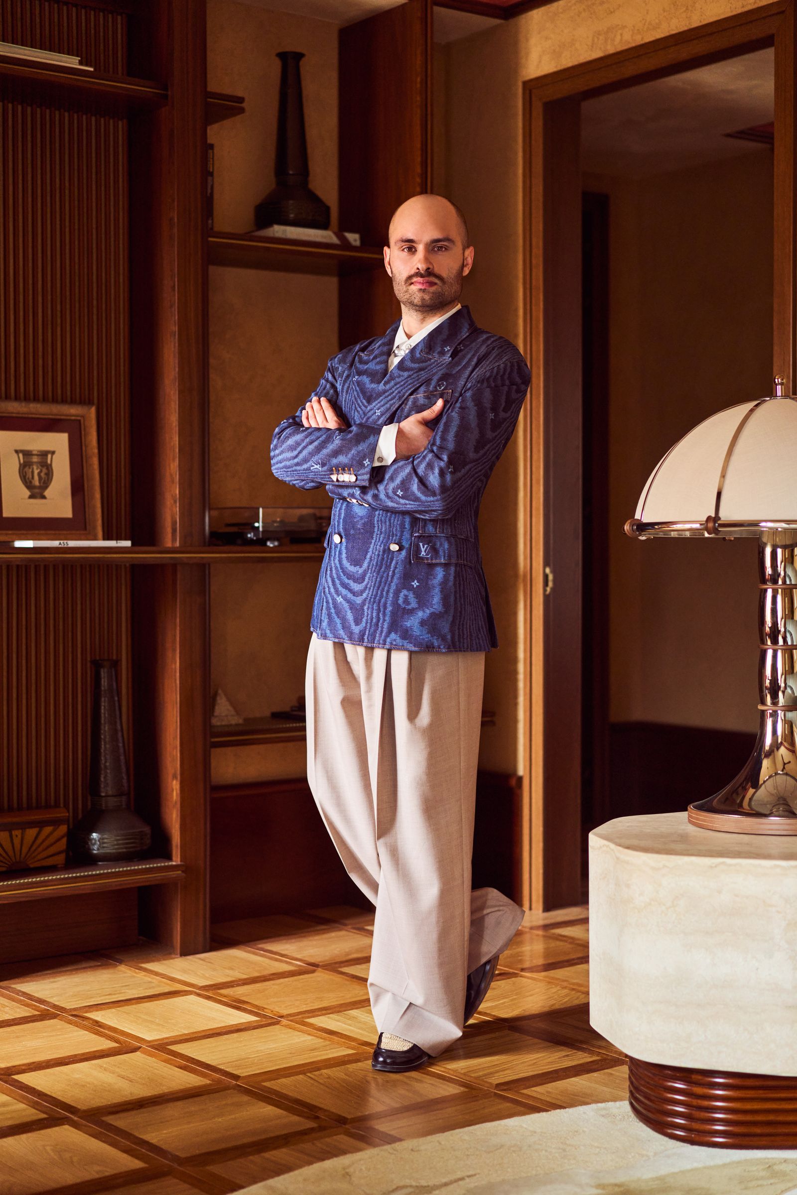 Image may contain Lamp Person Standing Adult Indoors Interior Design Clothing Pants Table Lamp Footwear and Shoe