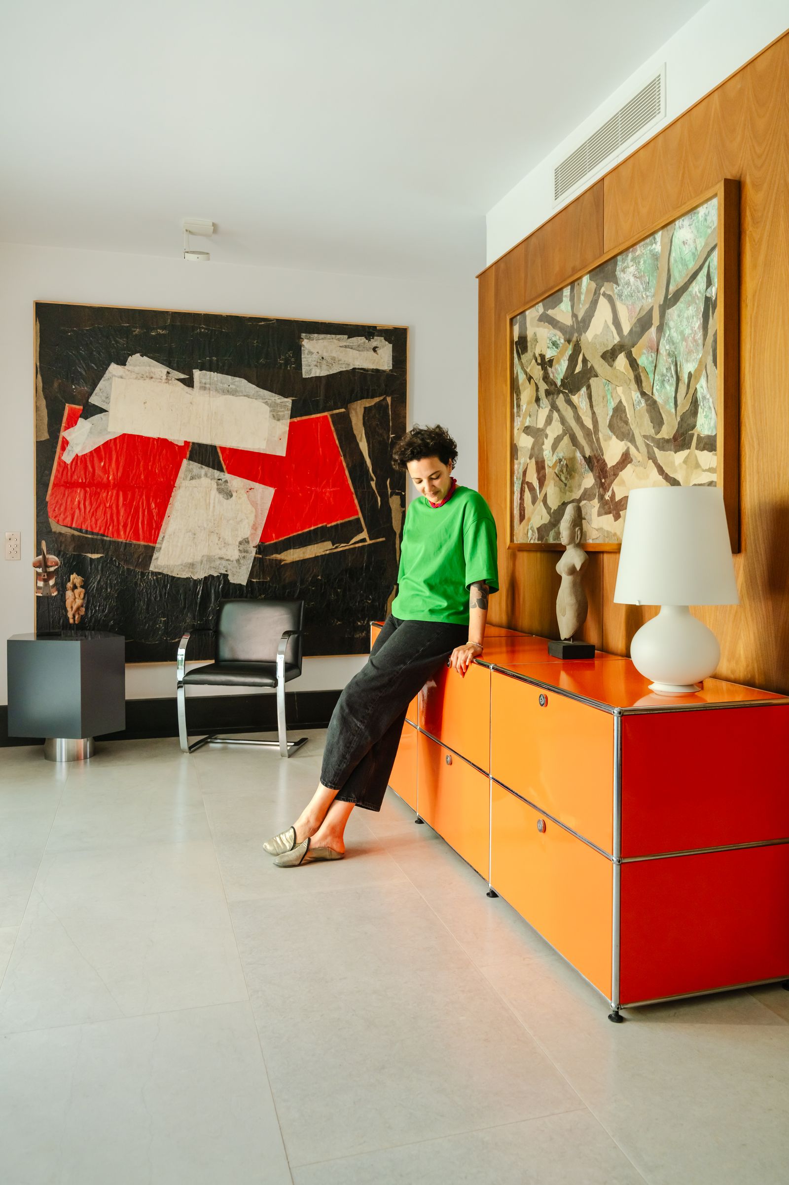 Image may contain Indoors Interior Design Person Teen Furniture Lamp Clothing Pants Chair and Table Lamp