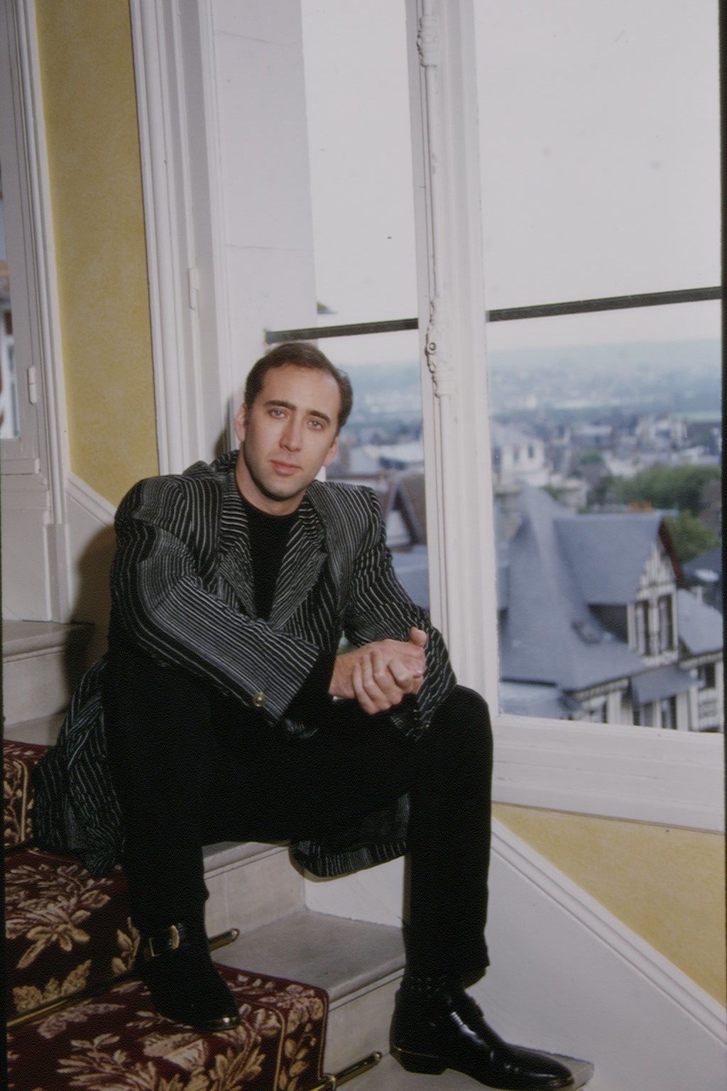 Image may contain Nicolas Cage Person Sitting Face Head Photography Portrait Adult Clothing Formal Wear and Suit